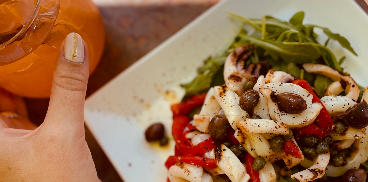 Plate of grilled calamari and refreshing summer drink